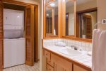 Guest bath features a shower, sink, toilet and washer and dryer. 